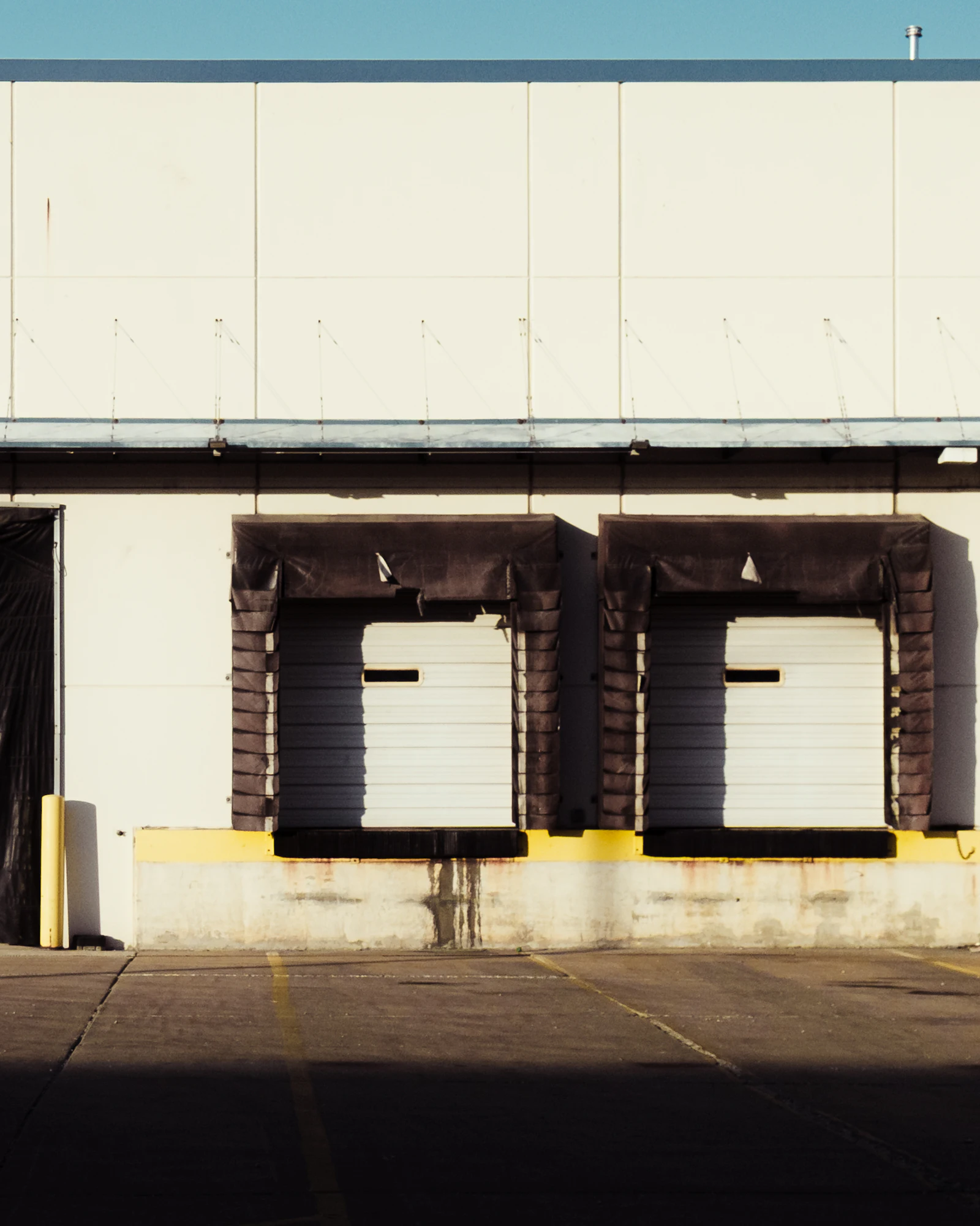 Loading dock doors with dock seals and a concrete dock edge on a warehouse wall