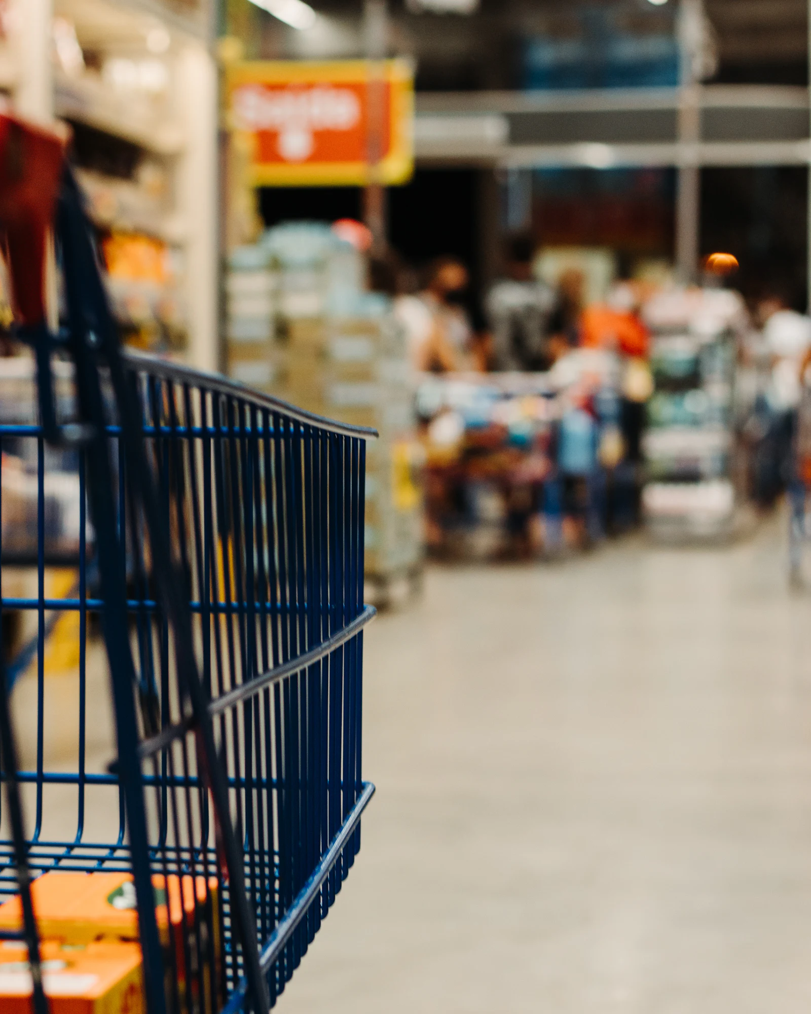 Shopping cart in a grocery store aisle with the shelves out of focus