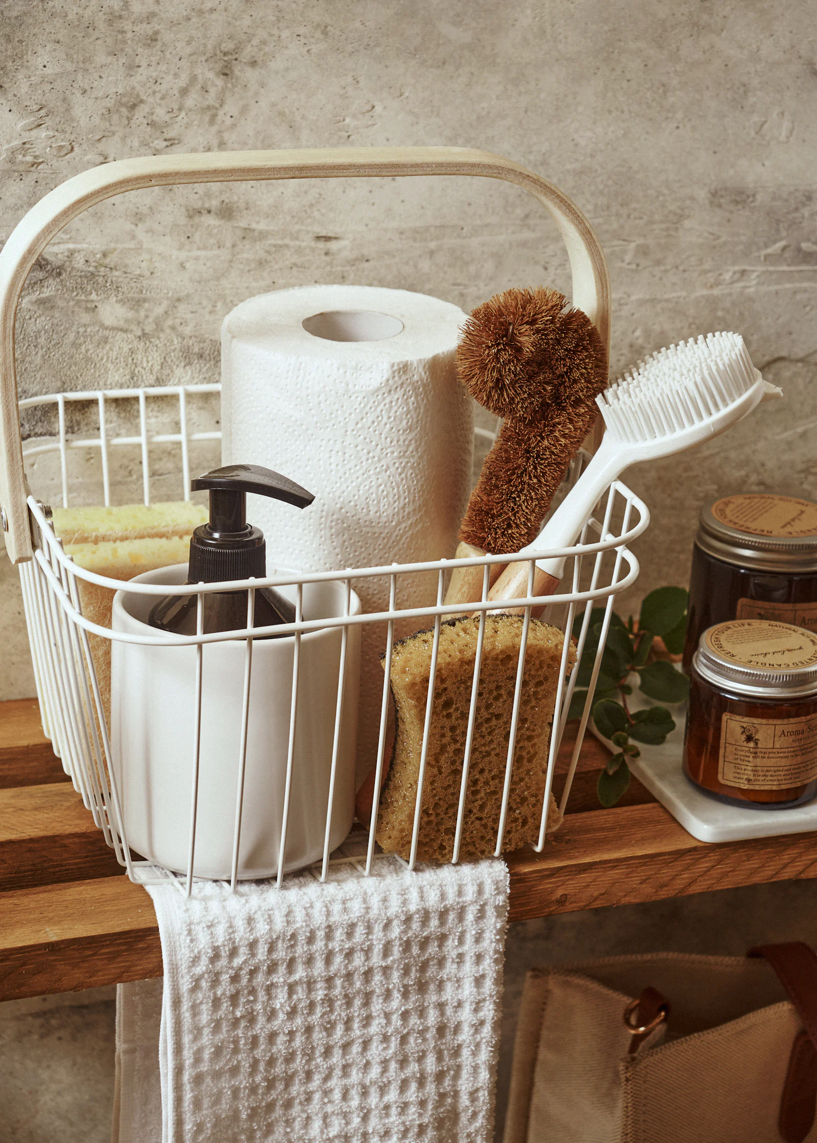 Wire basket holding a paper towel roll, scrub brushes, sponges, and a soap pump