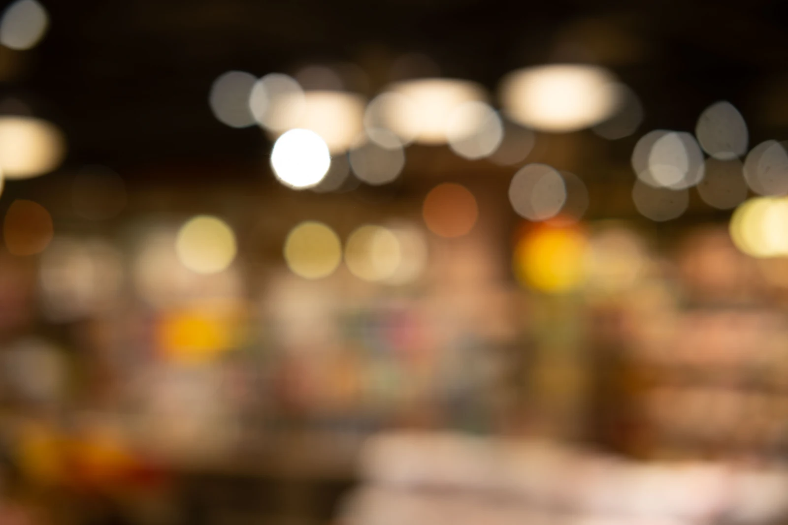 Out-of-focus shelves and ceiling lights inside a small store